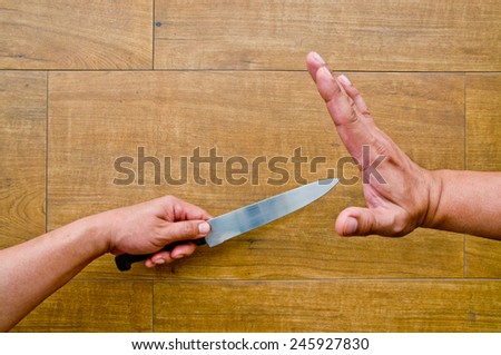 stop violence (hand holding knife and another hand try to stop)
