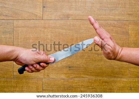 stop violence (hand holding knife while another hand try to stop)