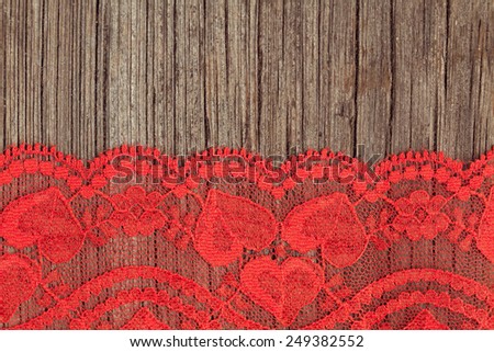 Red lace pattern art texture on wooden background