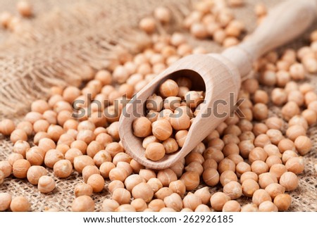 Dry chickpeas dietic healthy nutrition food in wooden spoon on vintage textile background