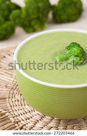 Tasty vegetarian broccoli soup recipe in a green bowl on vintage background