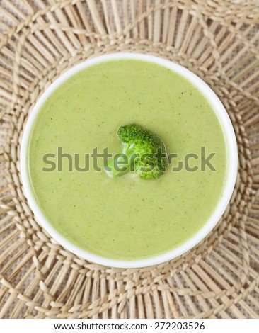 Homemade broccoli cream soup vegan recipe in green bowl. Top view