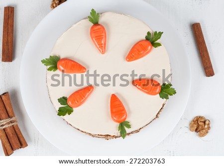 Homemade carrot sponge cake with little carrots and  cream on white background