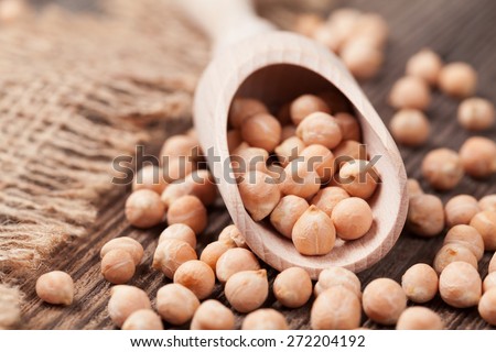 Organic raw chick peas healthy protein nutrition super food in wooden spoon on dark background. Close up view