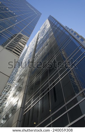 perspective view to steel light blue background of glass high rise building skyscraper commercial modern city