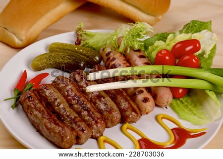Stack of cooked sausages with red hot chilli peppers on a plate