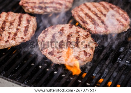 Preparing a batch of ground beef patties or frikadeller on grill or BBQ