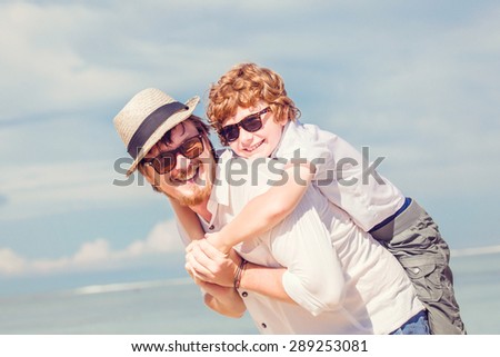 Hipster father with beard and red haired son having great happy time at a summer day. Vacation, happy and friendly family, holidays concept