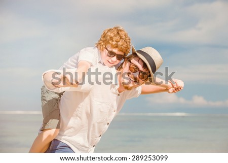 Happy father  father with beard and red haired son wearing sunglasses having happy summer time at a sunny day on vacation. Family, hapiness, travel concept