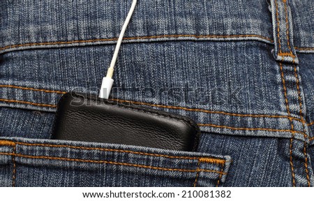 mobile phone in the pocket of jeans with headphones connected