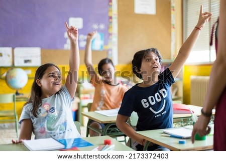 Group of primary school students with raised hand in class. Concept of learning, education and development in early childhood. Stock foto © 