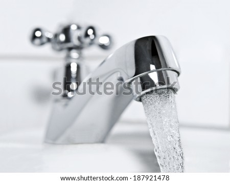 drinking water flows from a chrome water tap.