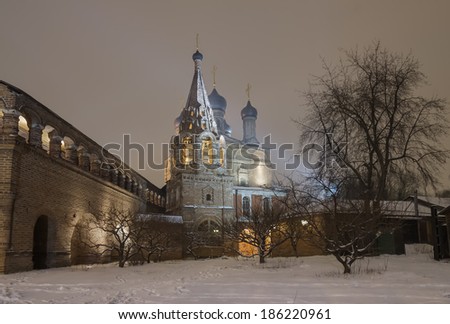 Russia, Moscow. Krutitsy courtyard of winter evening. Assumption Cathedral and bell tower in the snowfall