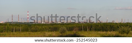 Summer evening panoramic landscape with petrochemical processing plants on the horizon. Russia, Tatarstan, Nizhnekamsk