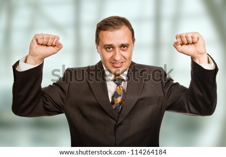 successful business man winning with arms wide open at the office