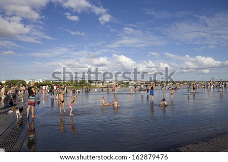 BORDEAUX, FRANCE - AUGUST 8: Bordeaux water mirror full of unidentified people in one of the hottest summer days, having fun in the water, on August 8, 2012 in Bordeaux, France.