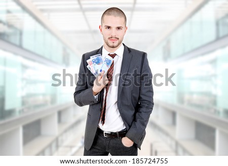 happy young business man with money at the office