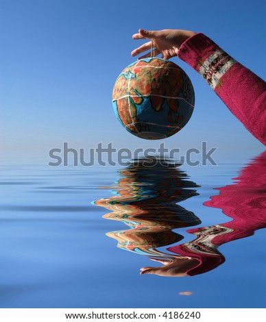globe in the hand, with reflection in the water