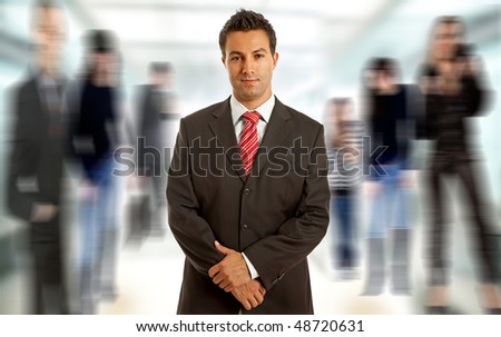 Young business man portrait smiling, among out of focus people