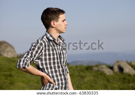 pensive young casual man at the top of the mountain