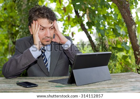 worried businessman with digital tablet, outdoors