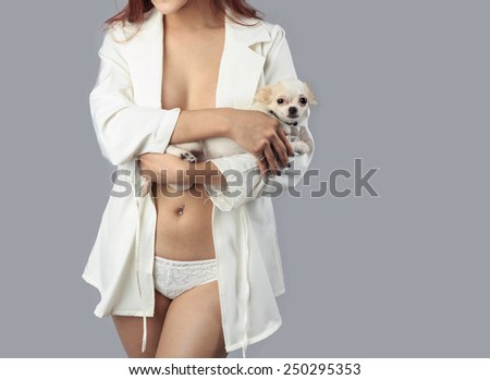 beautiful sexy body of woman model  holding a cute little dogs - in studio shot