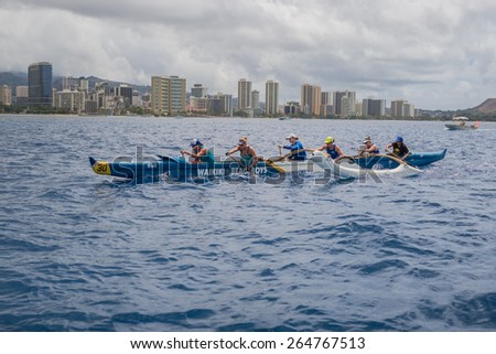 Honolulu, Hawaii, USA, March 29, 2015:  A top-rated Women\'s Outrigger Canoe team practices for the upcoming Hawaii State Outrigger Canoe Competition off shore from Waikiki on a cloudy,  rainy morning.