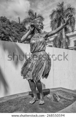 Honolulu, Hawaii, USA, April 12, 2015: The Honolulu Hula Maiden greets visitors to the Port of Honolulu at Aloha Tower.  The statue is over eight feet tall and made of bronze.
