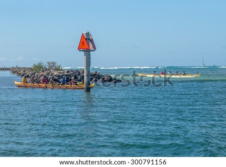 Honolulu, Hawaii, USA, July 28, 2015: Mid-morning view of Waikiki as outrigger canoe crews wait for a break in the large surf at Waikiki.  Outrigger canoes are a growing sport in Hawaii.