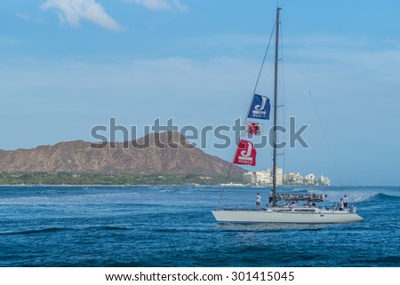 Honolulu, Hawaii, USA, July 30, 2015:  Late evening view of a sailboat motoring into the Ala Wai Harbor with Diamond Head in the background.  Recreational sailing is increasingly popular in Hawaii.