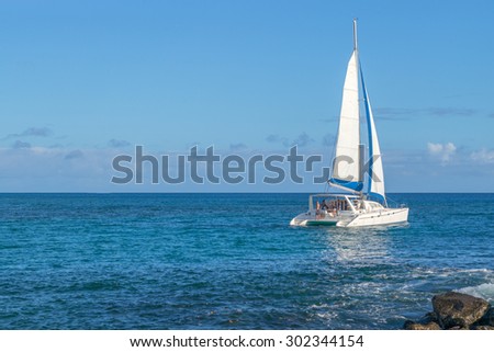 Honolulu, Hawaii, USA, August 2, 2015: Evening departure of a catamaran under full sail from Honolulu and headed for the island of Kauai.  Catamarans are increasingly popular in the Hawaiian Islands.
