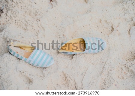 a pair of shoes on the sand