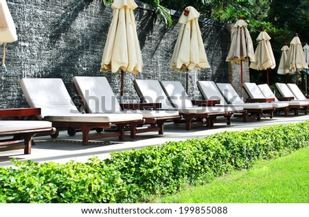 Lounge chairs by poolside for relax