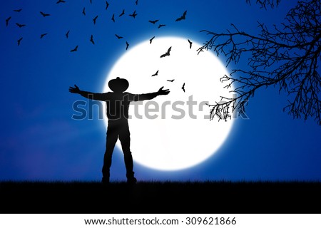 Man wore hat outstretched arms at   beautiful moon of night.