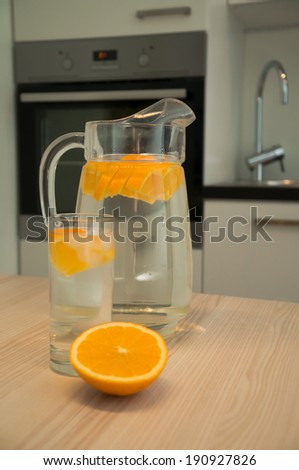 Carafe of water with orange on the kitchen table