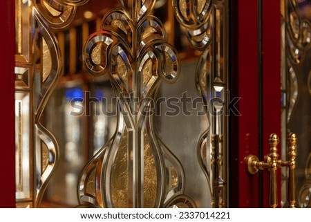 Beveled glass in an old chique door, decorated material with gold details and shiny reflections in the design, art deco style Foto stock © 