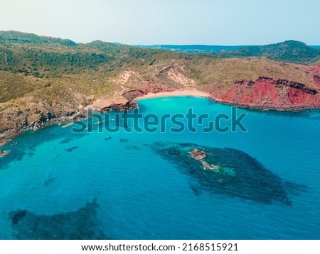 Aerial photography of the incredible landscape of turquoise waters and cliffs of Cala del Pilar, in the northern part of Menorca, Balearic Islands. A paradise of turquoise blue waters, red sand. Foto stock © 
