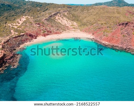 Aerial photography of the incredible landscape of turquoise waters and cliffs of Cala del Pilar, in the northern part of Menorca, Balearic Islands. A paradise of turquoise blue waters, red sand. Foto stock © 