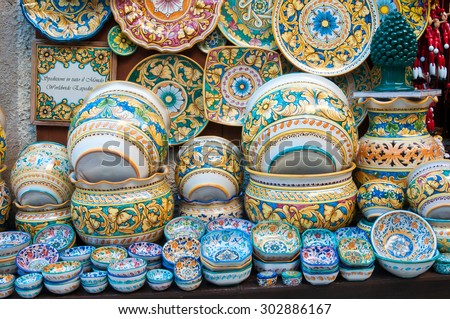Various decorated ceramic dishes, vases, and bowls for sale outside a souvenir shop in Erice, Sicily