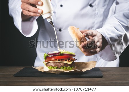 Similar – Image, Stock Photo Chef preparing burgers at grill plate on international urban street food festival.