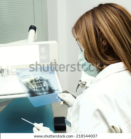 Dentist looking at X-ray of teeth and gums