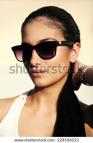 Young woman portrait with sun glasses and pony tail