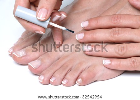 Woman applying enamel on toes and finger nails