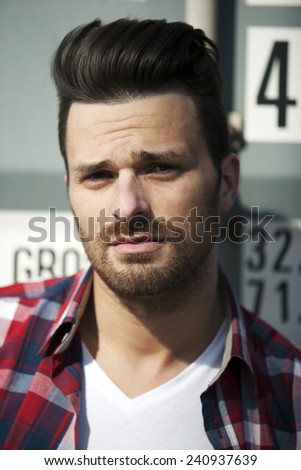 Handsome man in striped shirt and t shirt with beard and funky haircut