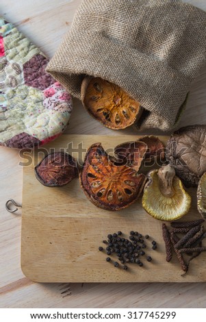 Healthy herbs table (dried long pepper,bare fruit,mushroom,black pepper) on wooden background.