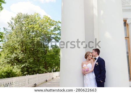 Beautiful sexy model girl in white dress. Wedding couple. Man in suit. Beauty blonde bride with brunette groom. Female and male portrait with bouquet. Woman with lace veil. Cute lady and guy outdoors