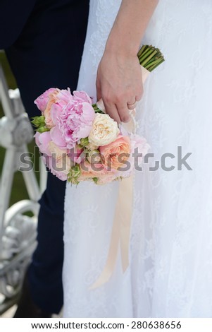 Female and male portrait with bouquet. Wedding couple. Beautiful sexy model girl in white dress. Man in suit. Beauty bride with groom. Woman in bridal gown. Cute lady and guy outdoors