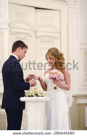 Marriage ceremony. Beautiful sexy model girl in white dress. Wedding couple. Man in suit. Beauty blonde bride with brunette groom. Female and male portrait. Woman with lace veil. Cute lady and guy