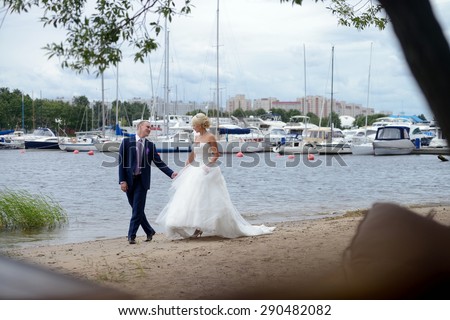 Wedding couple on the nature is walking. Beautiful model girl in white dress. Handsome man in suit. Beauty bride with groom. Female and male portrait. Woman with lace veil. Lady and guy outdoors