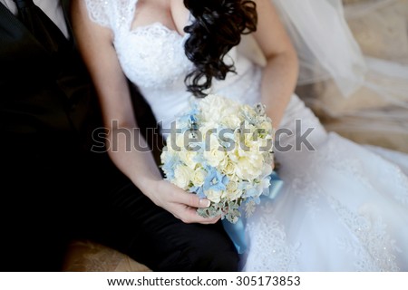 Wedding couple with bouquet. Female and male portrait. Beautiful model girl in white dress. Man in suit. Beauty bride with groom. Woman in bridal gown. Cute lady and guy indoors